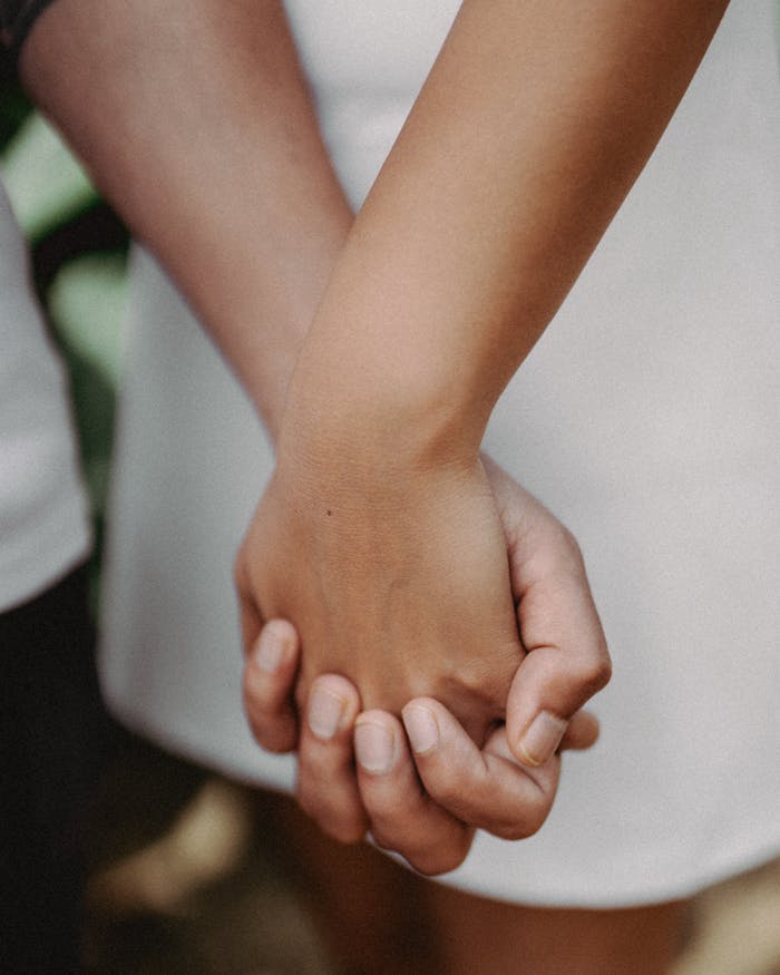 Close-up of couple holding hands, symbolizing love and connection in Toronto.